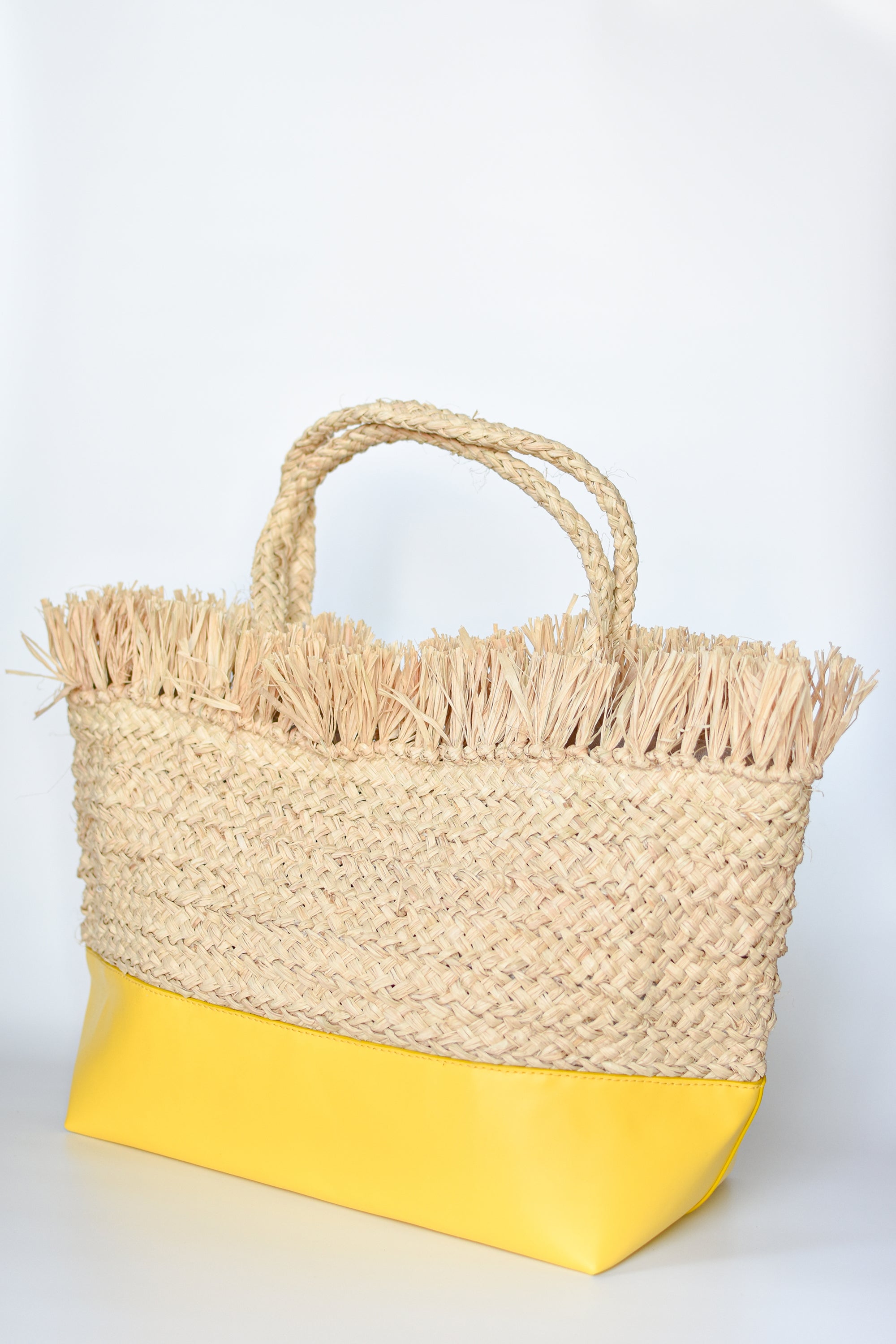 Natural raffia straw tote with linen lining and yellow color block base.