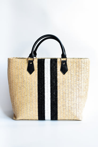 Benicia straw tote bag with black leather handles and black & white center stripe.