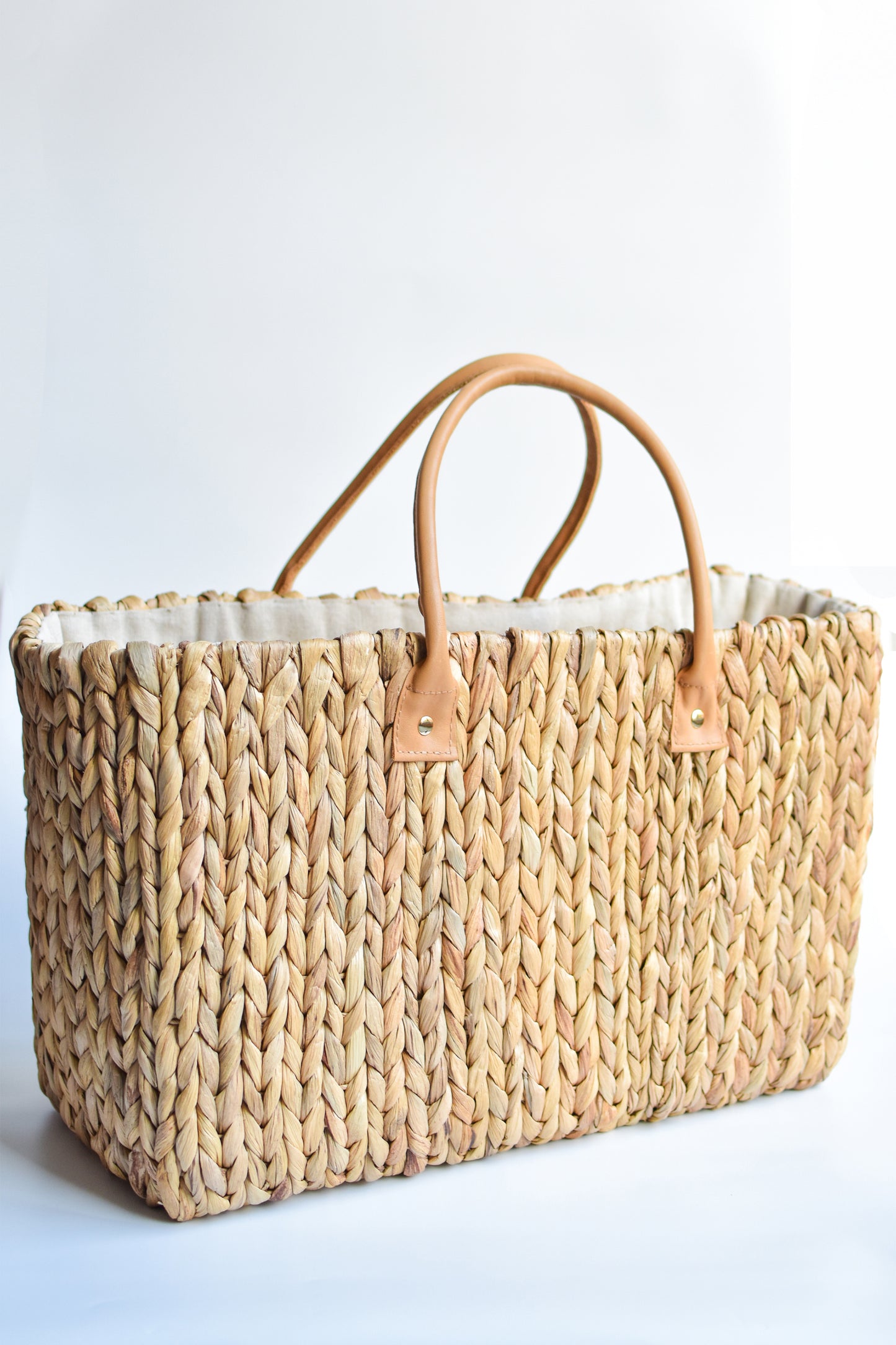 Extra large natural hyacinth straw tote with matching leather handles. 