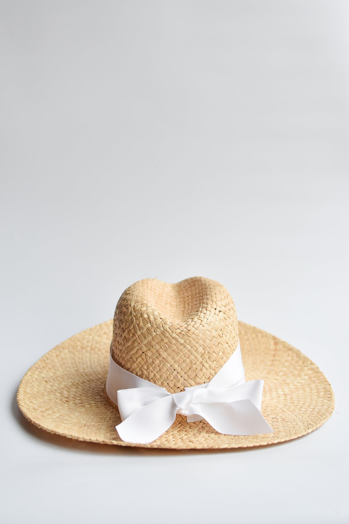 Natural raffia straw panama hat with white grosgrain tie.