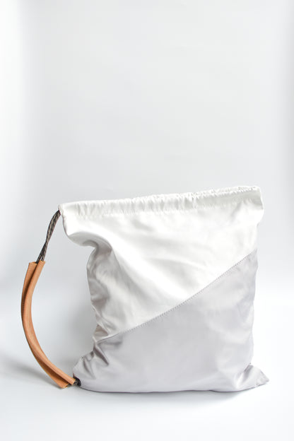 Sporty nylon sling bag in white and gray with natural leather straps. 