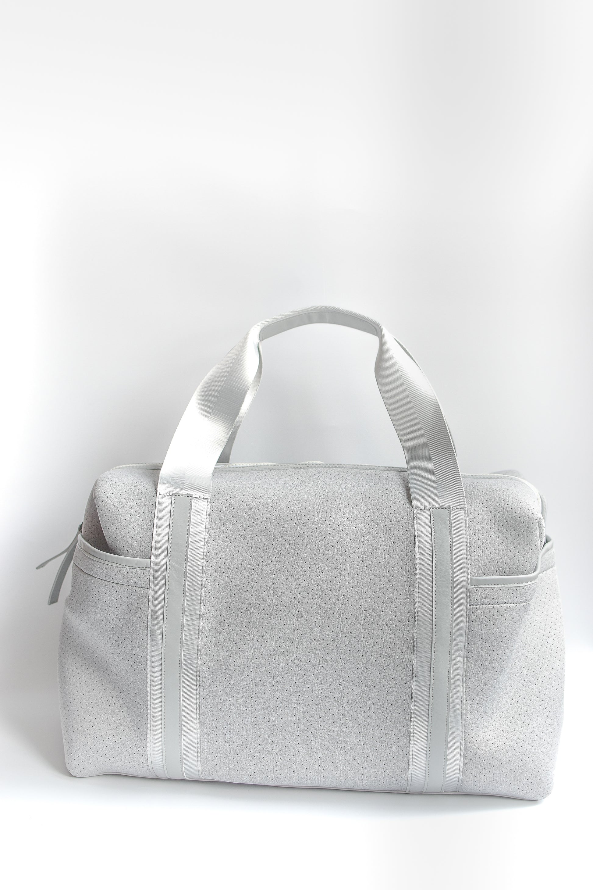 Callahan light gray perforated neoprene duffel bag with grey straps and leather details. 