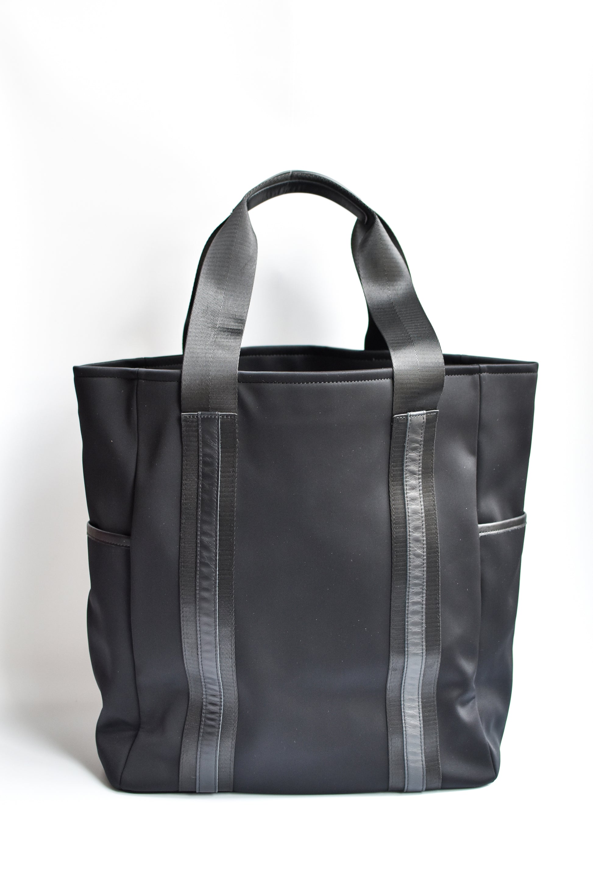 Black neoprene tote bag with high shine cinch top closure and leather details. 