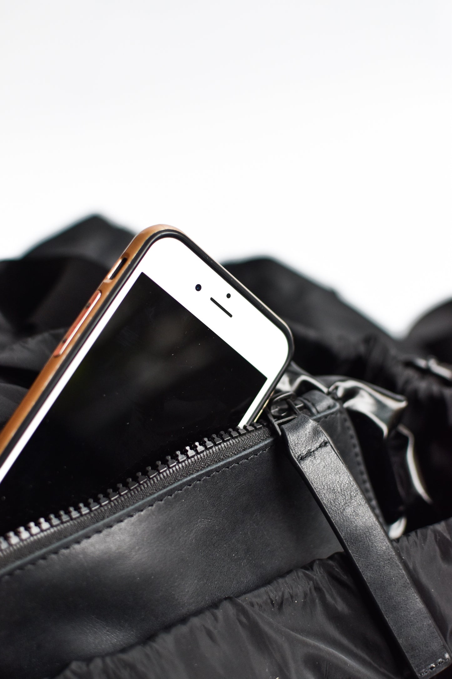 Interior leather pocket detail on black nylon convertible backpack tote with leather details.