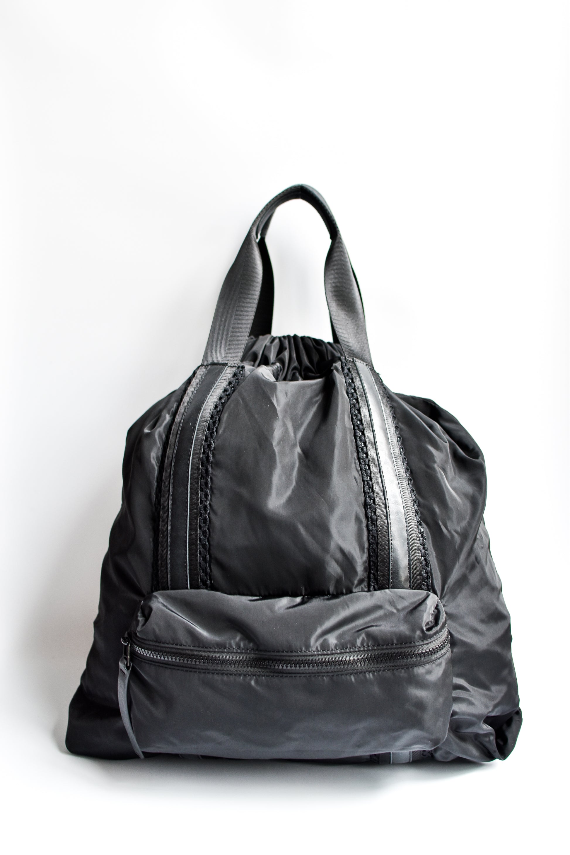 Black nylon convertible backpack tote with leather details.