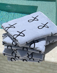 stack of Anya & Niki beach towels on the edge of the pool