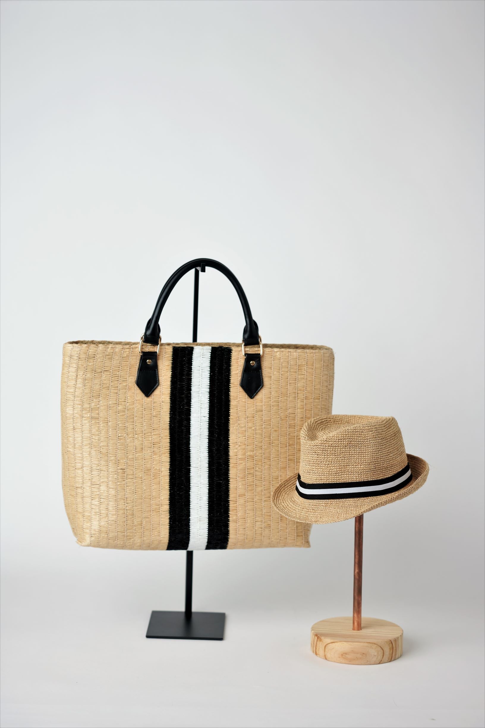 Collection of Anya &amp; Niki Benicia straw tote bag with black leather handles and black &amp; white center stripe, along with the Essential crochet straw hat with black and white band. 