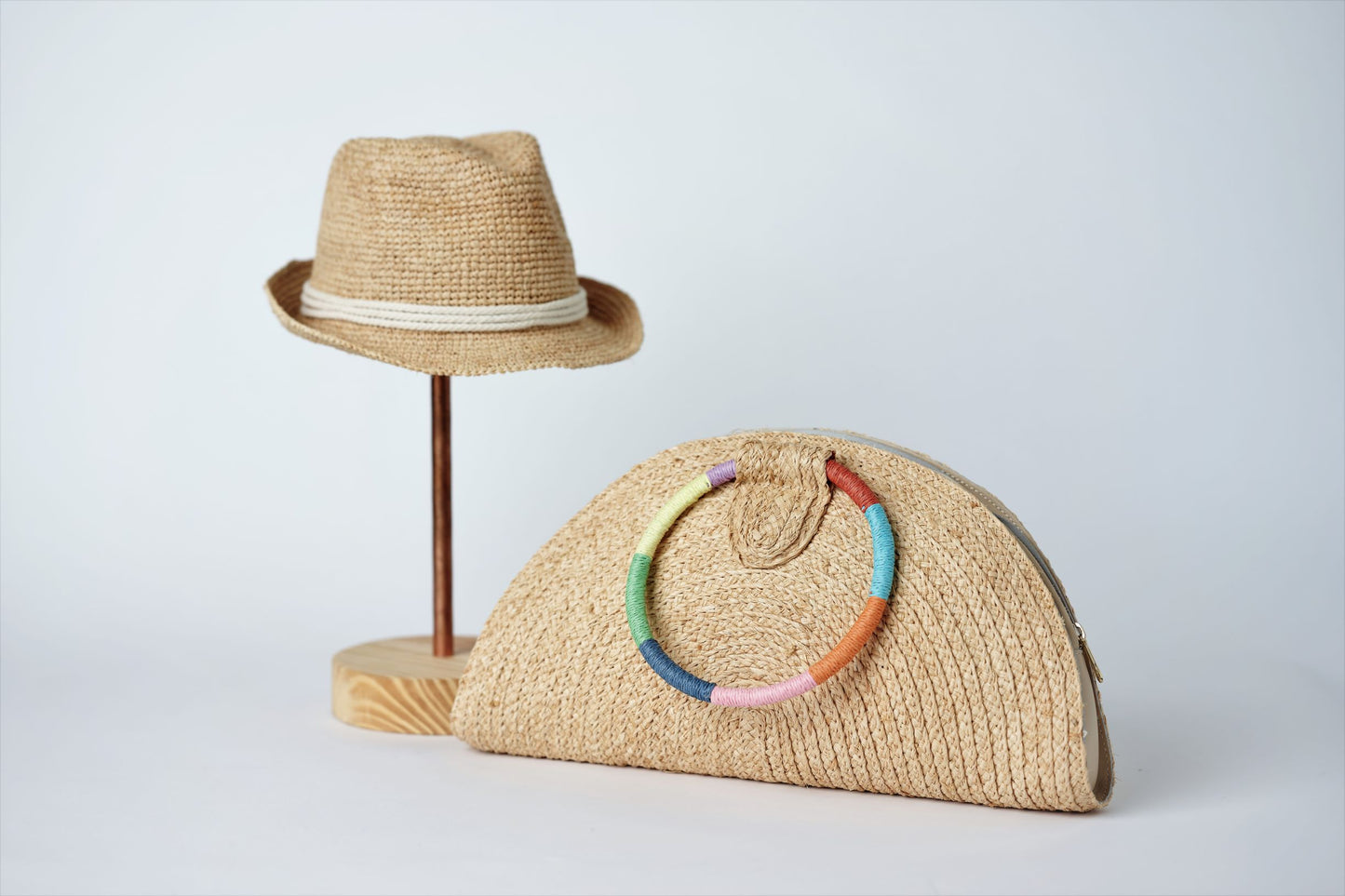 Collection of Anya & Niki Essential crochet straw hat with rope band and the Palma half-moon straw clutch with circle handle.