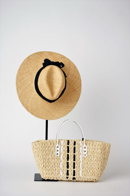 Everywhere straw hat with black grosgrain band and small straw tote bag with leather handles. 