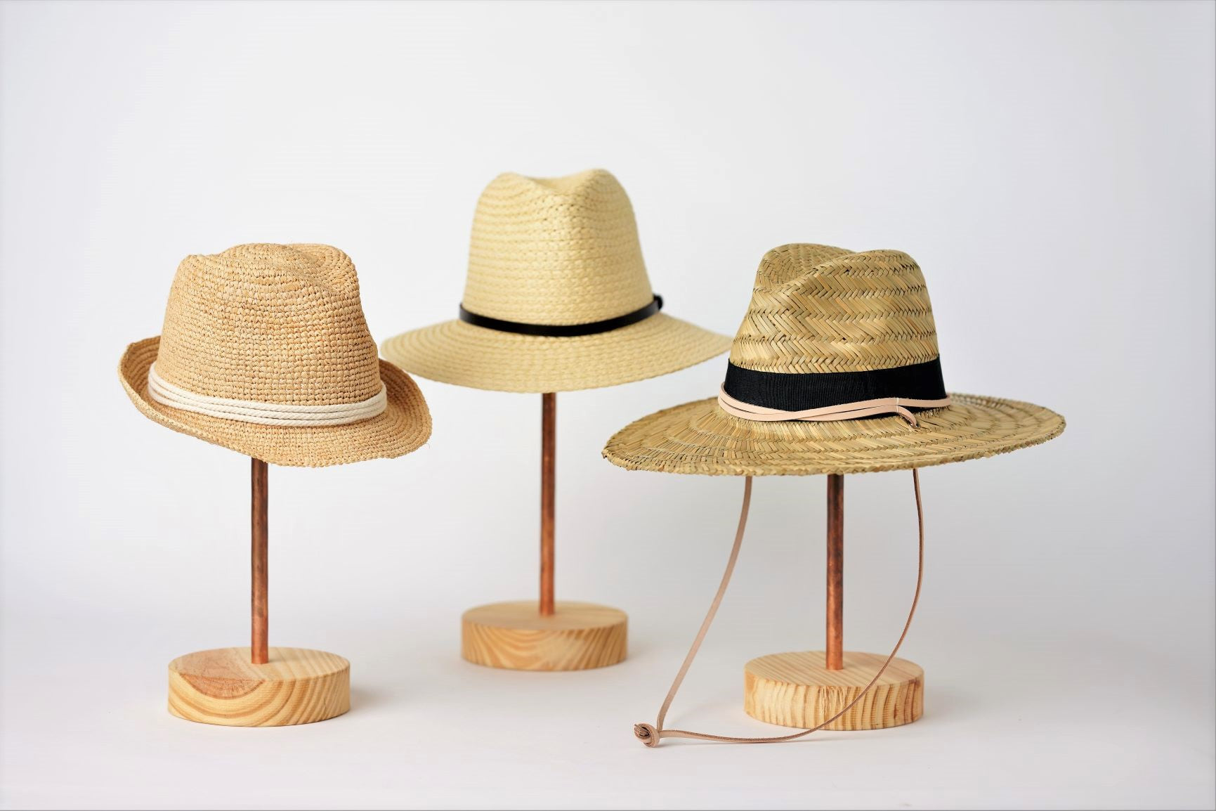 Collection of Anya & Niki straw hats, the Essential crochet straw hat with rope band, the Favorite Straw Hat with leather band, and the Tower Straw Hat with leather chin strap.