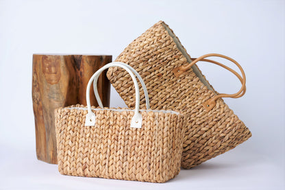Collection of two Anya & Niki hyacinth straw tote bags with leather handles in a medium and large size.