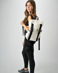 Person holding the Anya & Niki Newberry Backpack - a white mesh backpack with leather details and clear drawstring top.