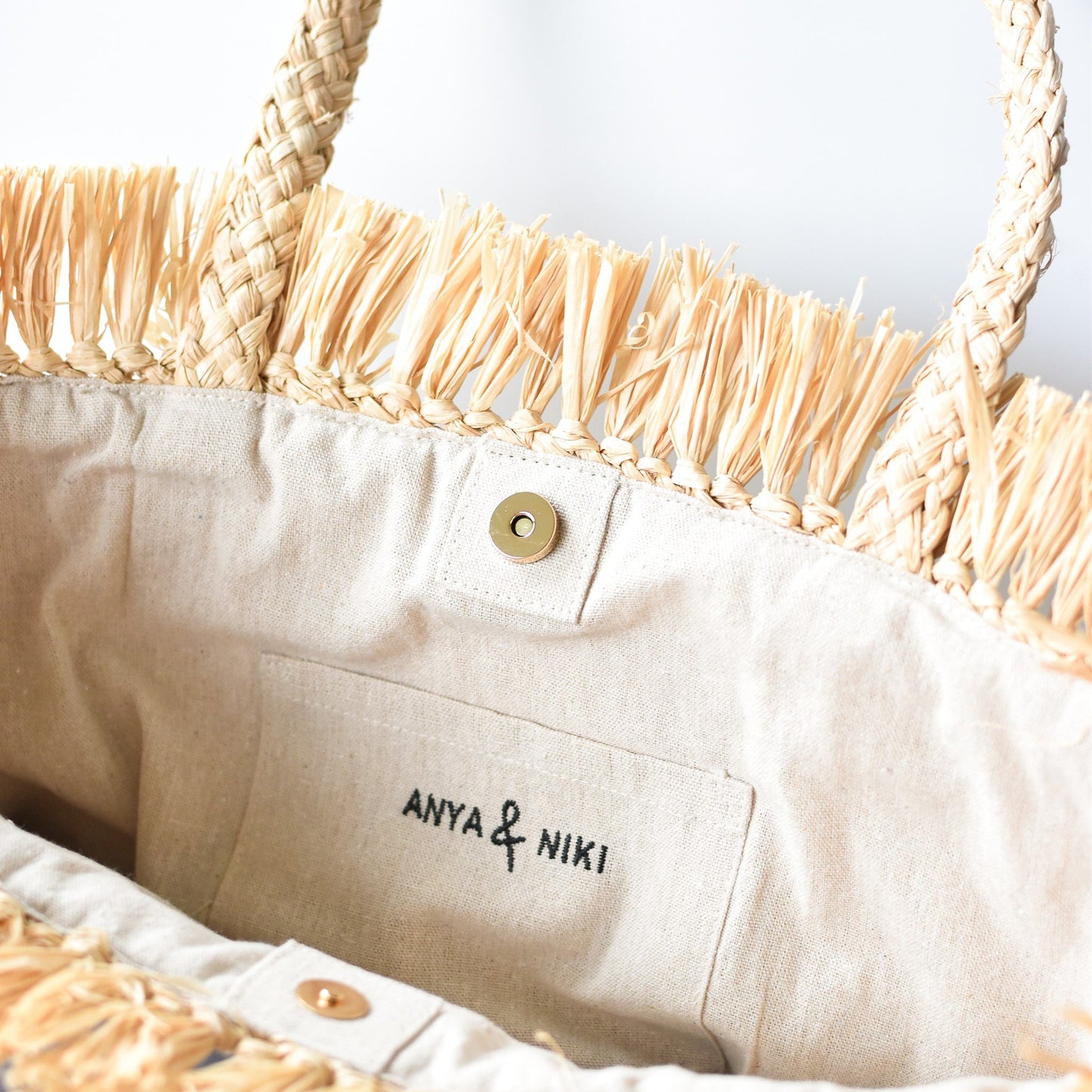 Close up of lining lining on natural raffia straw tote with yellow color block base.
