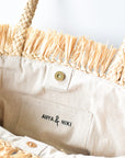 Close up of lining lining on natural raffia straw tote with yellow color block base.