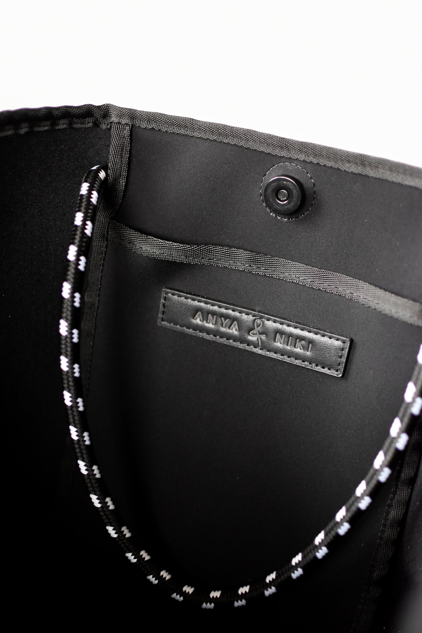 Close up of interior pocket on gray perforated neoprene tote bag.