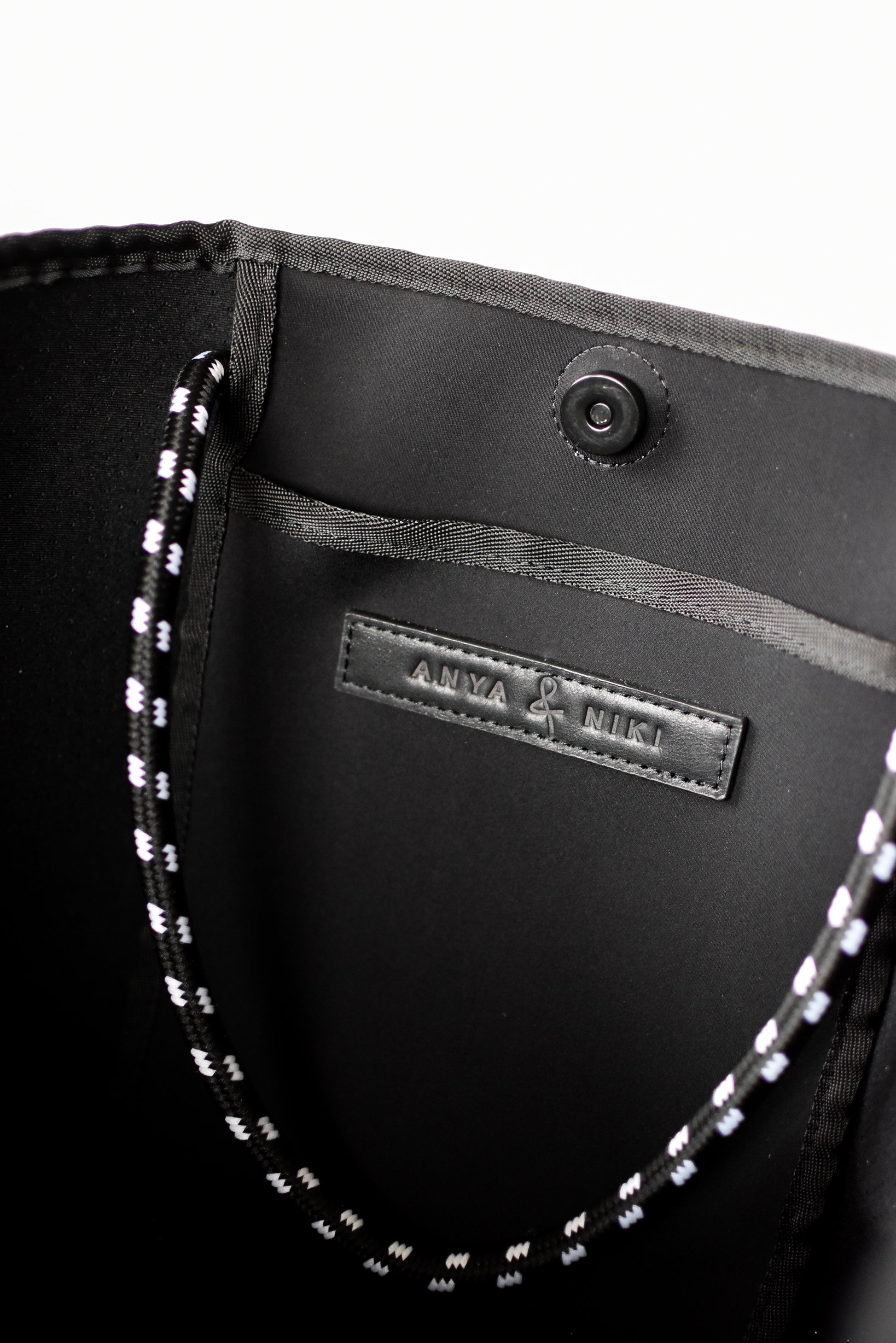 Close up of interior pocket on gray perforated neoprene tote bag.