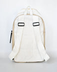 Back strap detail on off white faux croc embossed Casselberry backpack with cinch top and back zipper compartment.