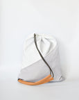 Sporty nylon sling bag in white and gray with natural leather straps. 