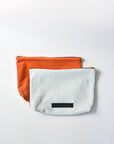 Washed denim and orange suede medium sized pouch with brass zipper and leather logo label.