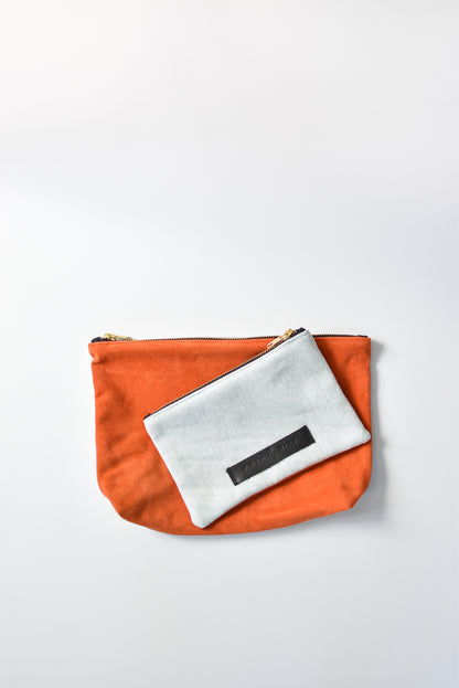 Washed denim and orange suede medium and small pouch with brass zipper and leather logo label.