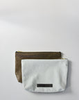 Bleached denim and fern colored embossed leather skin medium pouch with brass zipper and leather logo label.