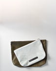 Bleached denim and fern colored embossed leather skin medium and large pouch with brass zipper and leather logo label.