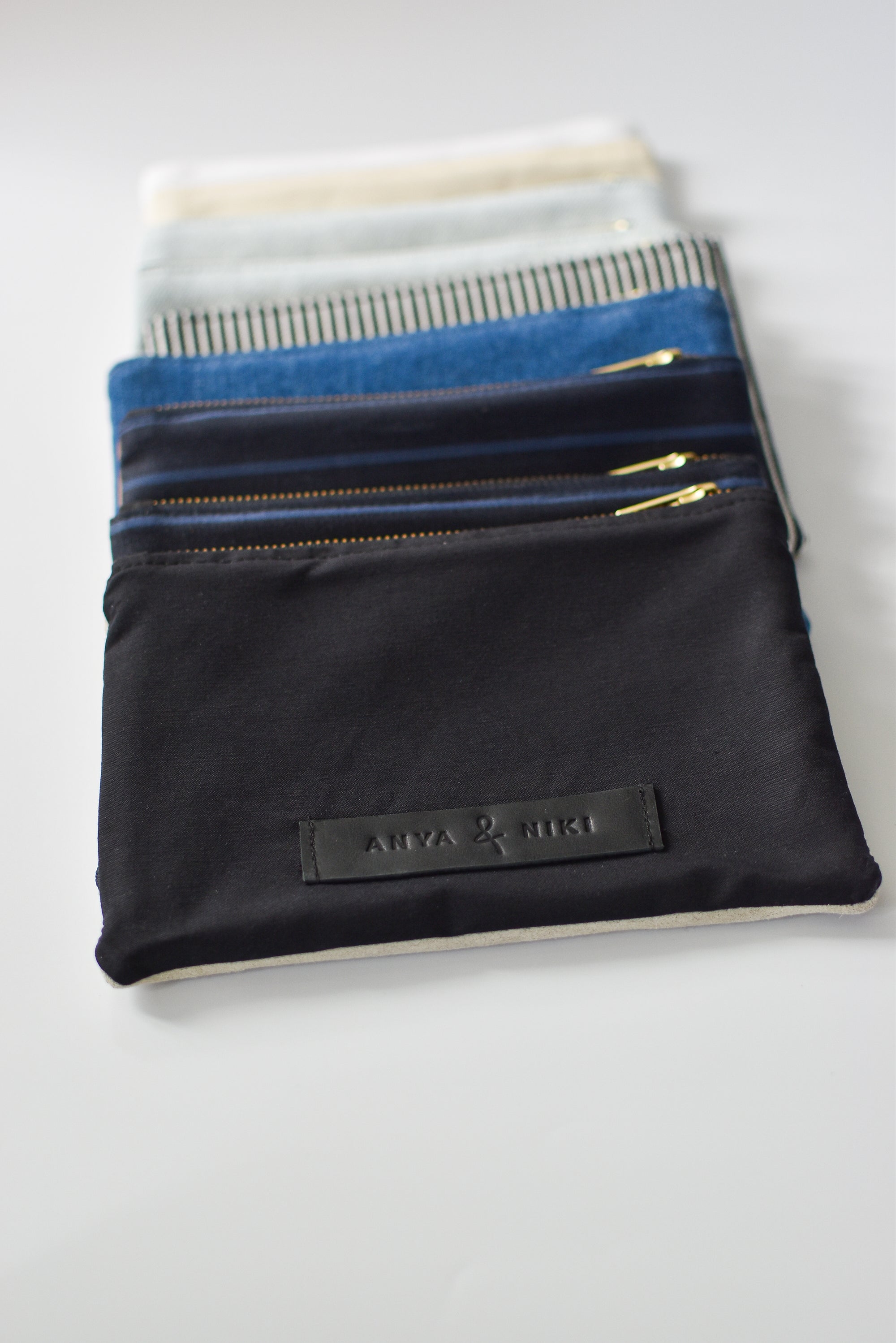 Collection of small limited edition leather and denim pouches from Anya & Niki. 