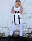 Person holding the Anya & Niki Newberry Backpack - a white mesh backpack with leather details and clear drawstring top.