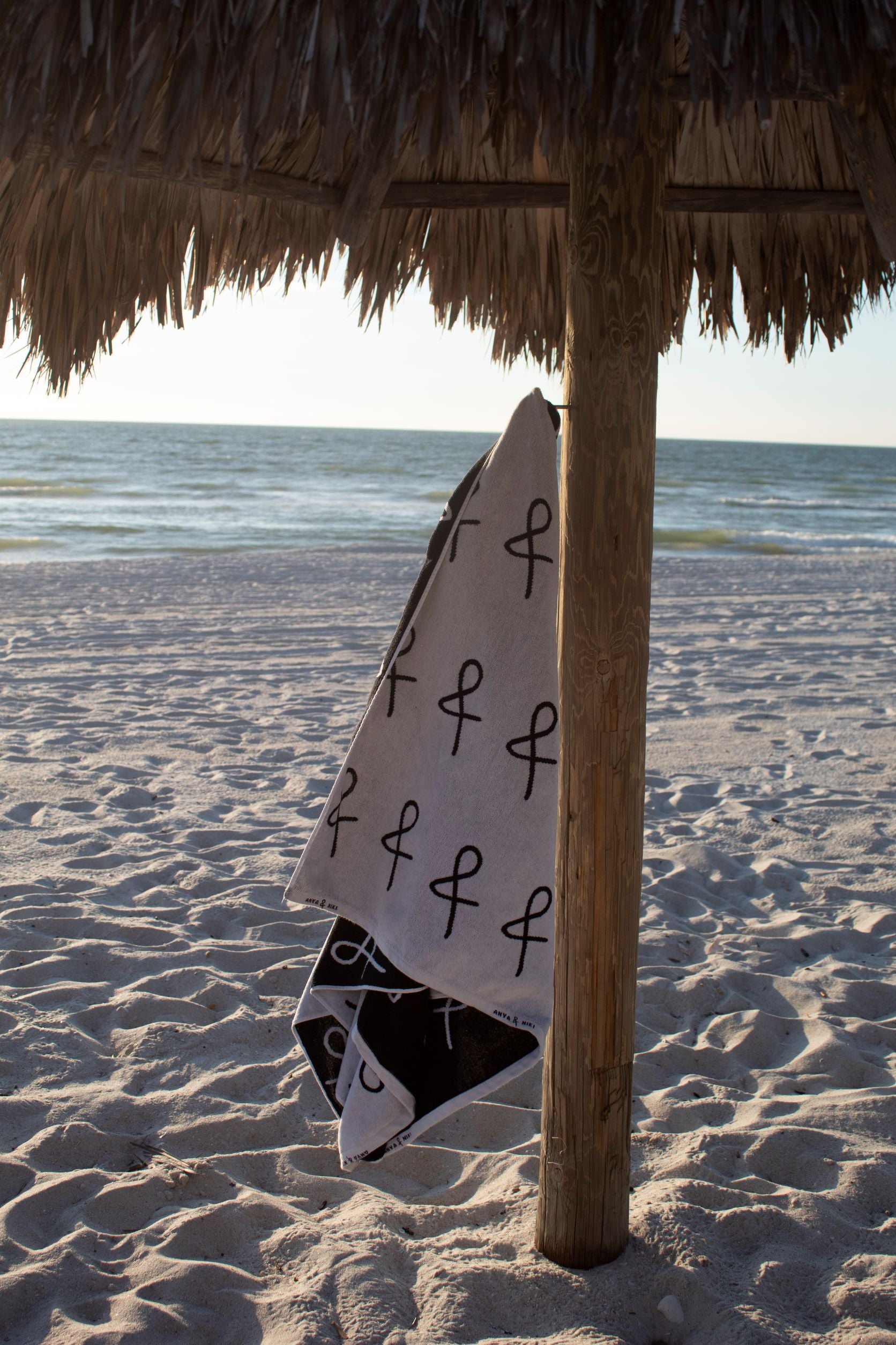 Anya &amp; Niki beach towel haning from cabana post at the beach