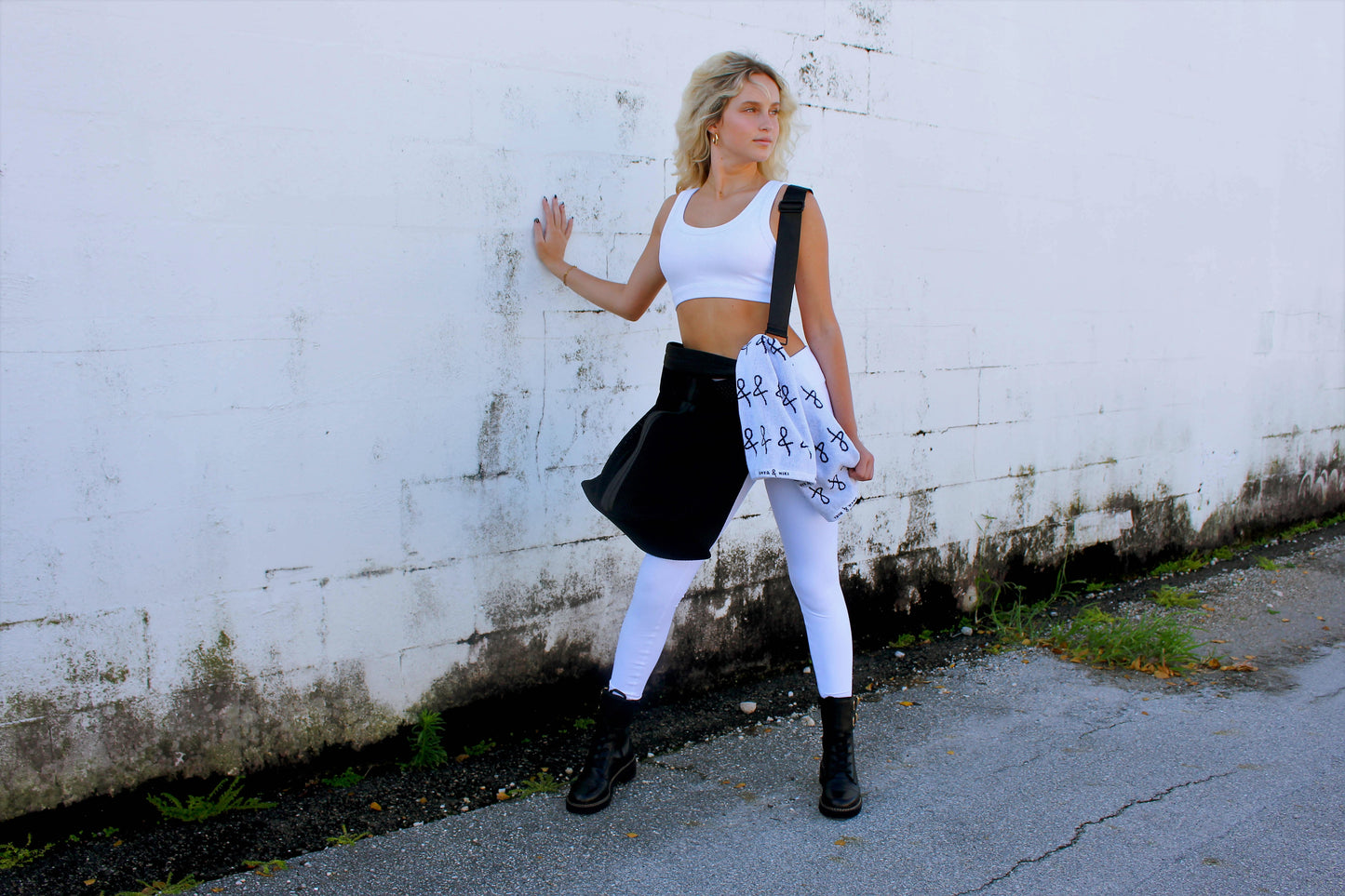 Person holding black sporty mesh tote bag with black leather and webbing details.