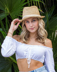 Person wearing the Anya & Niki Essential Hat - a natural colored crochet straw fedora hat with ivory rope band.