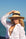 Person wearing raffia straw panama hat with black grosgrain tie