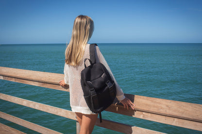 Person wearing the Anya & Niki Newberry backpack - a black mesh backpack with leather details and shiny silver drawstring top.