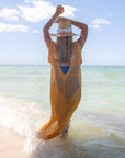 Person wearing the Everywhere Hat - a natural raffia straw panama hat with white grosgrain tie.