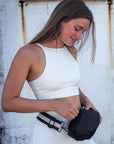 Person wearing black nylon belt bag with black crossbody strap with cream leather detail