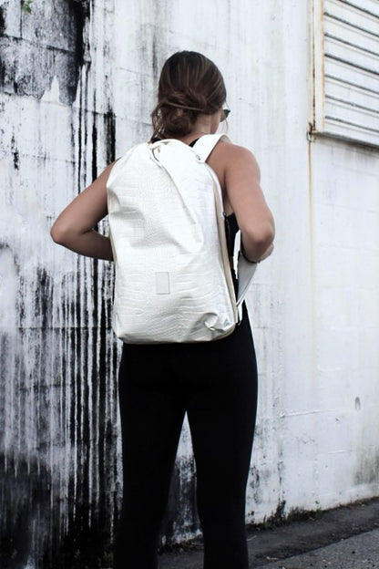 Person wearing off-white faux croc embossed Casselberry backpack