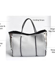 Perforated gray neoprene tote bag with black cord handle and adjustable high shine silver sides.