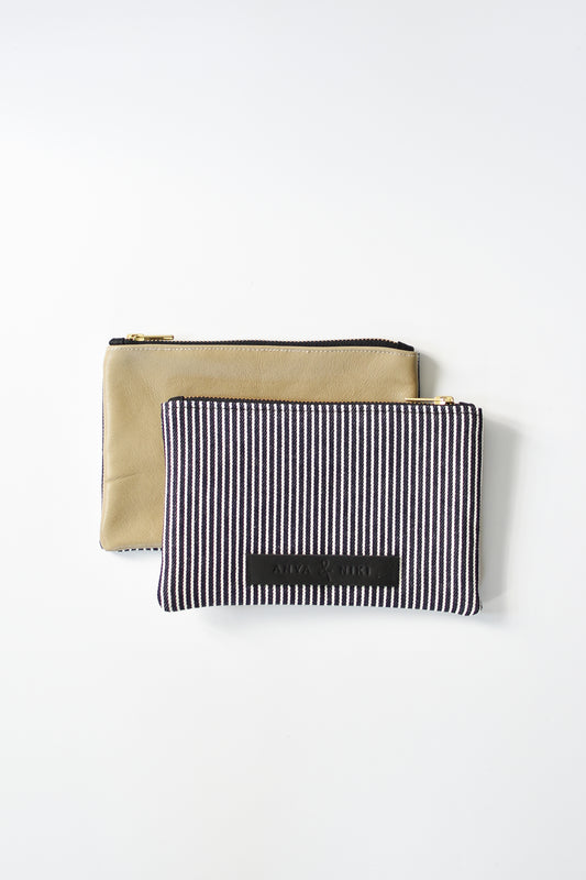 Railroad striped denim and taupe colored leather small pouch with brass zipper and leather logo label.