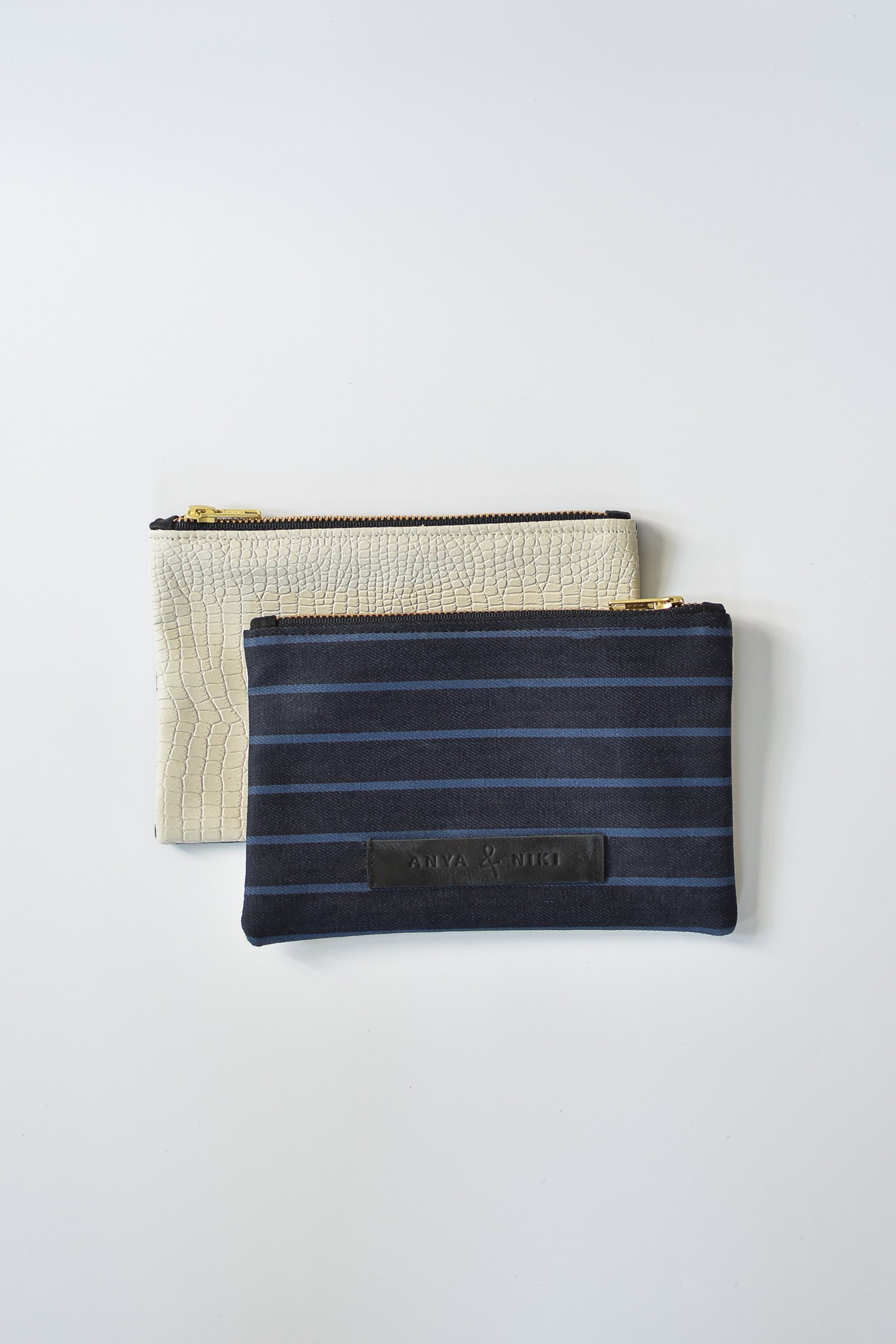 Striped dark denim and off-white croc embossed leather small pouch with brass zipper and leather logo label.