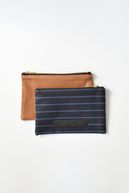 Striped dark denim and brown leather small pouch with brass zipper and leather logo label.
